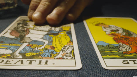Nahaufnahme-Einer-Person,-Die-Tarotkarten-Liest-Und-Die-Karten-Der-Hohepriesterin,-Der-Stärke-Und-Des-Todes-Auf-Den-Tisch-Legt